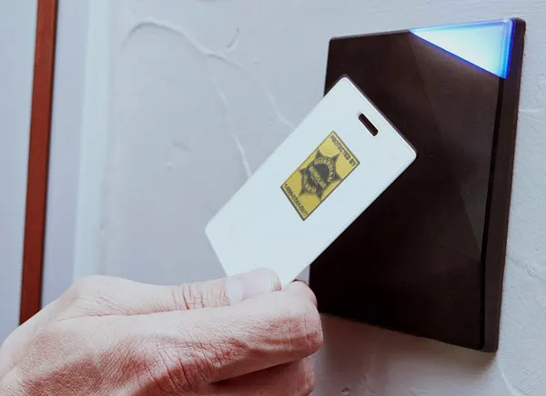 Access card held to a wall-mounted reader