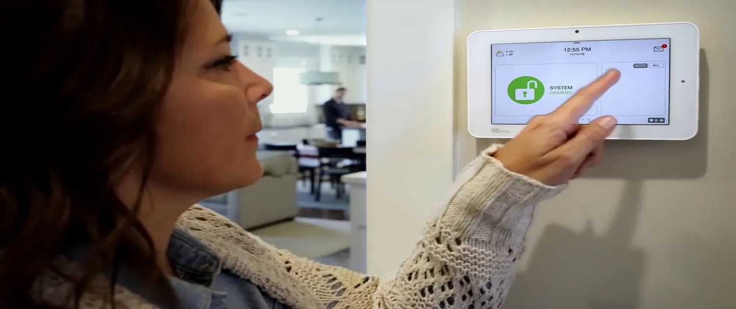 Homeowner using a wall-mounted touchscreen security panel